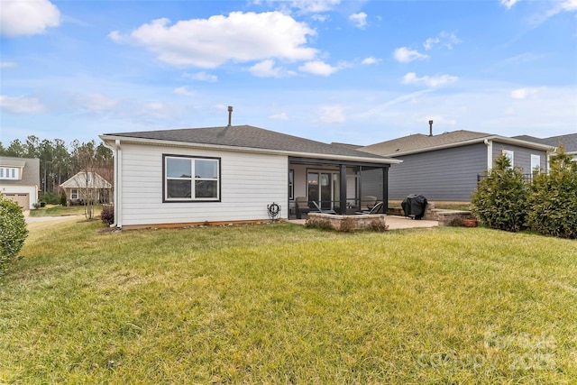 rear view of house featuring a yard and a sunroom