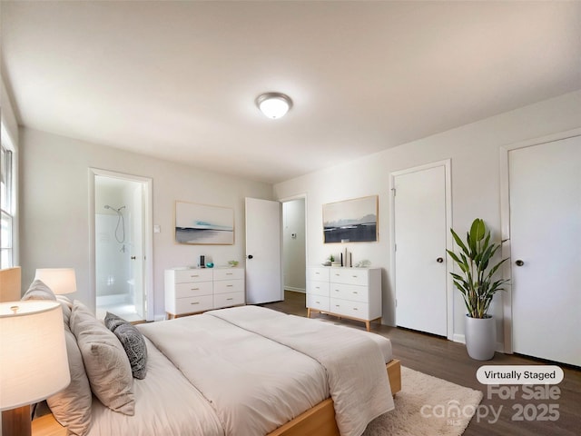 bedroom featuring ensuite bath and dark hardwood / wood-style flooring