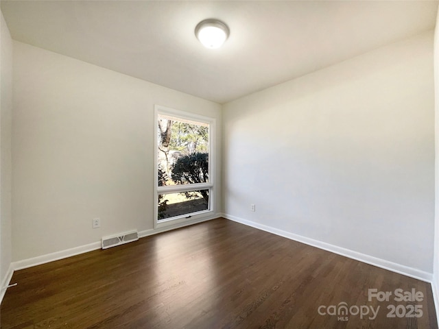 spare room with dark hardwood / wood-style flooring