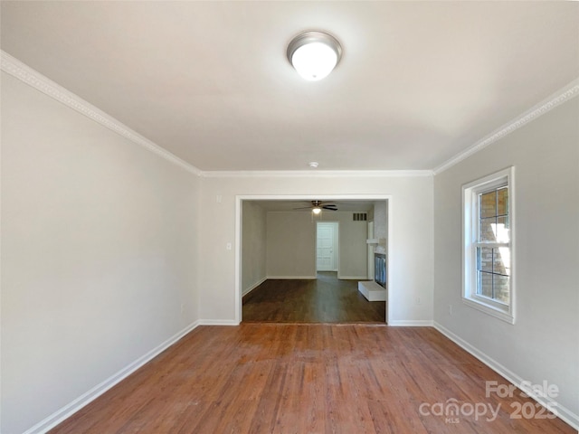 spare room with crown molding, ceiling fan, and dark hardwood / wood-style floors