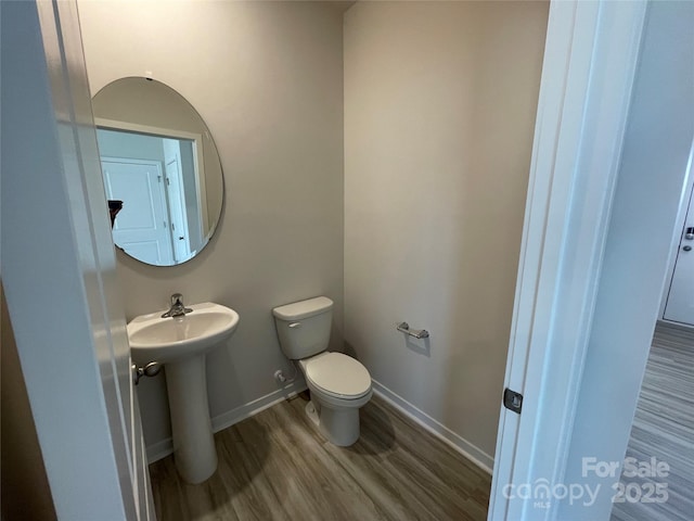 bathroom with wood-type flooring, sink, and toilet