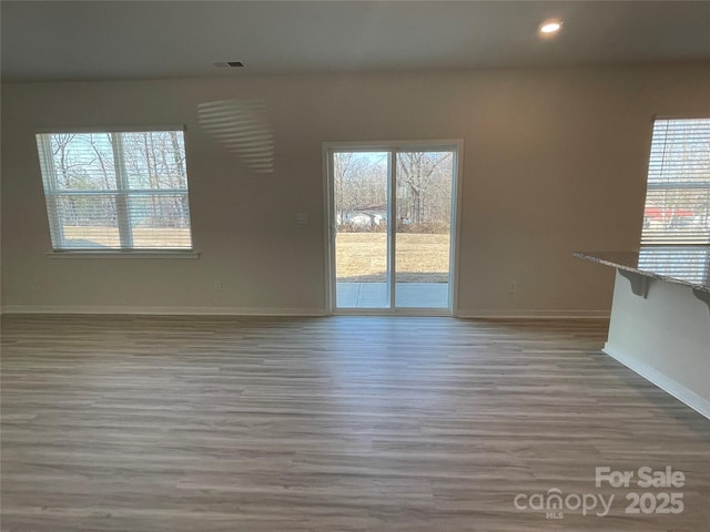 unfurnished living room with hardwood / wood-style flooring and plenty of natural light