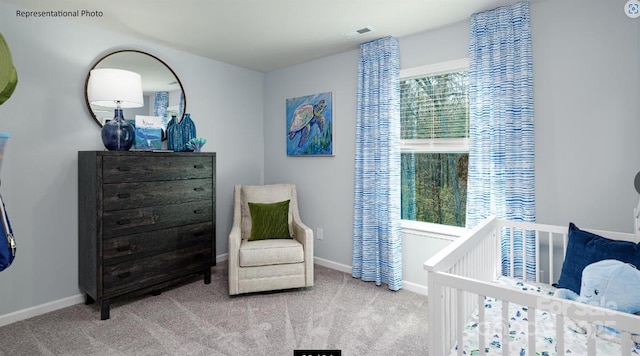 bedroom featuring light colored carpet and a nursery area