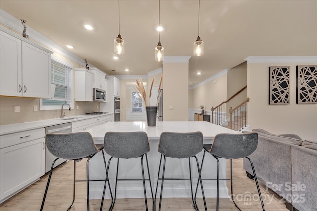 kitchen featuring white cabinetry, appliances with stainless steel finishes, a center island, and pendant lighting