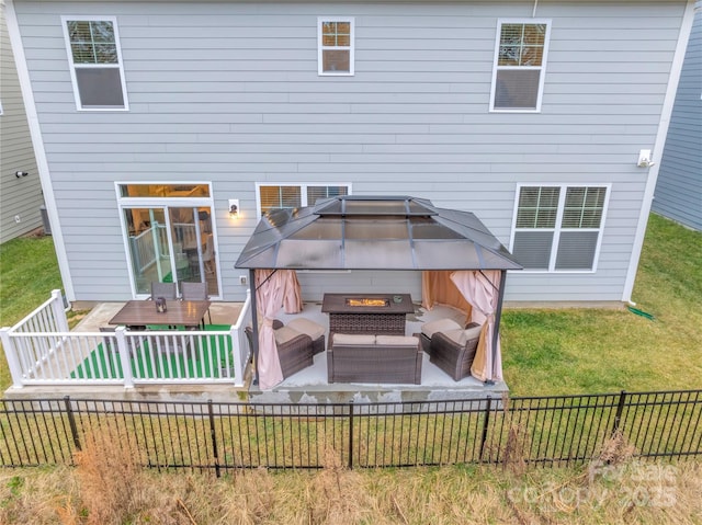 rear view of house with a gazebo, an outdoor hangout area, and a lawn