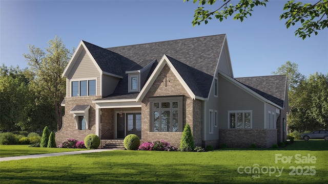 view of front facade with brick siding, roof with shingles, and a front yard