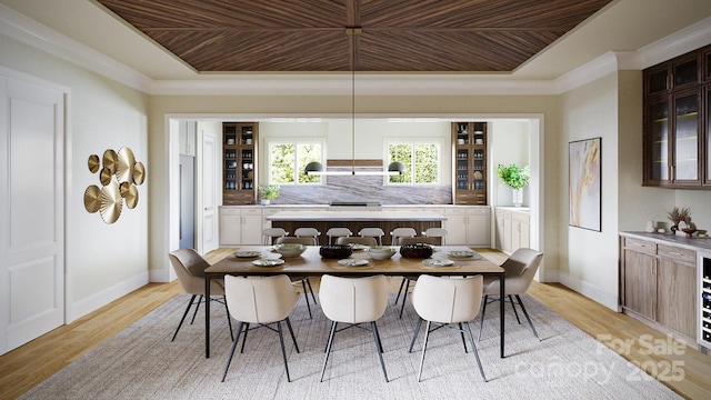 dining area featuring crown molding, light wood-type flooring, and a tray ceiling