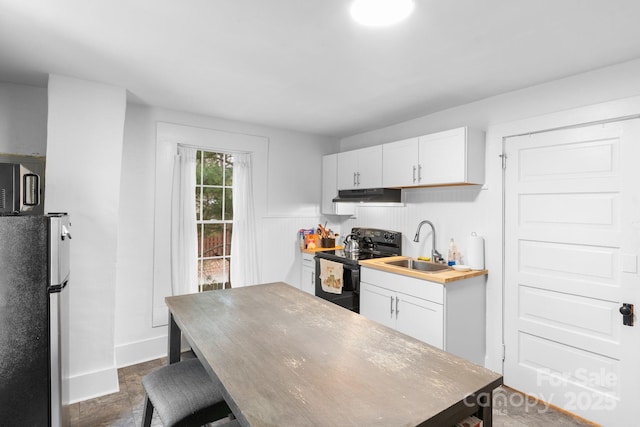 kitchen featuring sink, white cabinets, stainless steel refrigerator, and black range with electric cooktop