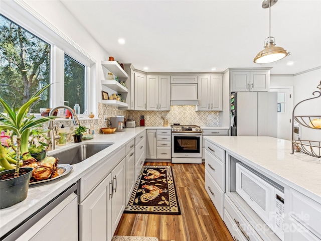 kitchen with sink, stainless steel gas stove, refrigerator, dishwasher, and custom range hood