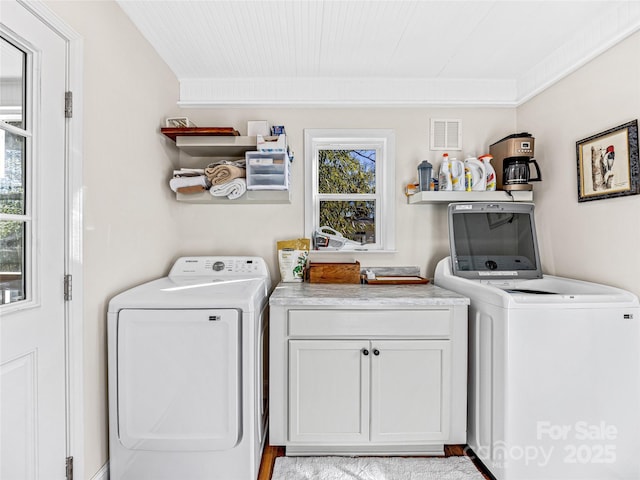 laundry area featuring cabinets, independent washer and dryer, and a healthy amount of sunlight