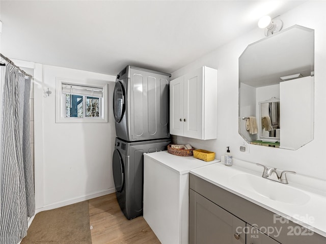 laundry room with sink, stacked washer and clothes dryer, and light wood-type flooring