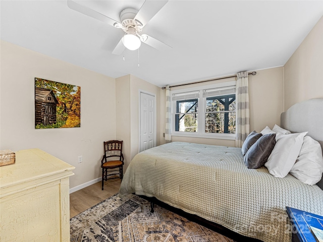 bedroom with ceiling fan, wood-type flooring, and a closet