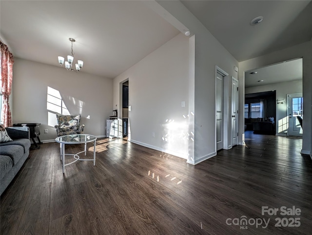 living room with baseboards, dark wood-style flooring, and an inviting chandelier