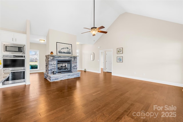 unfurnished living room featuring hardwood / wood-style flooring, a fireplace, high vaulted ceiling, and ceiling fan