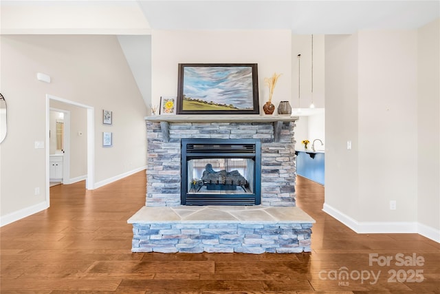 unfurnished living room with wood-type flooring, vaulted ceiling, and a fireplace