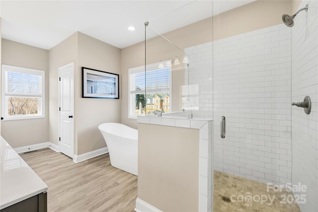 bathroom featuring hardwood / wood-style flooring, vanity, separate shower and tub, and a healthy amount of sunlight