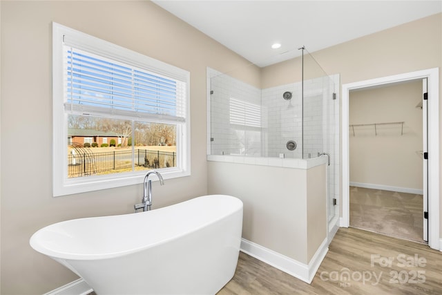 bathroom with wood-type flooring and independent shower and bath