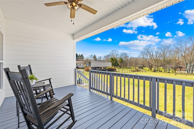 deck featuring ceiling fan and a yard