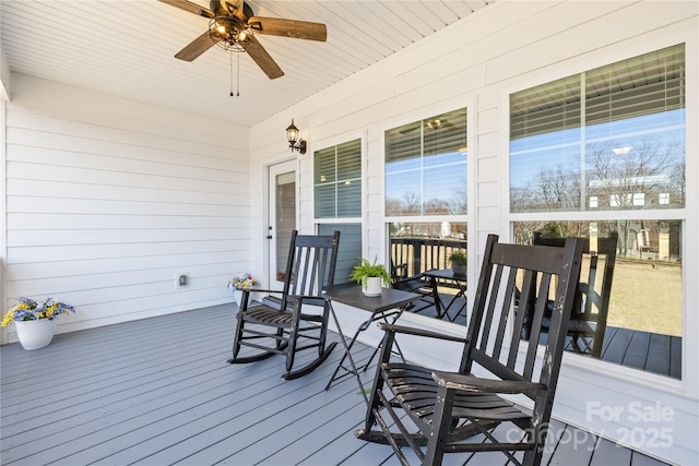 wooden terrace with ceiling fan and covered porch