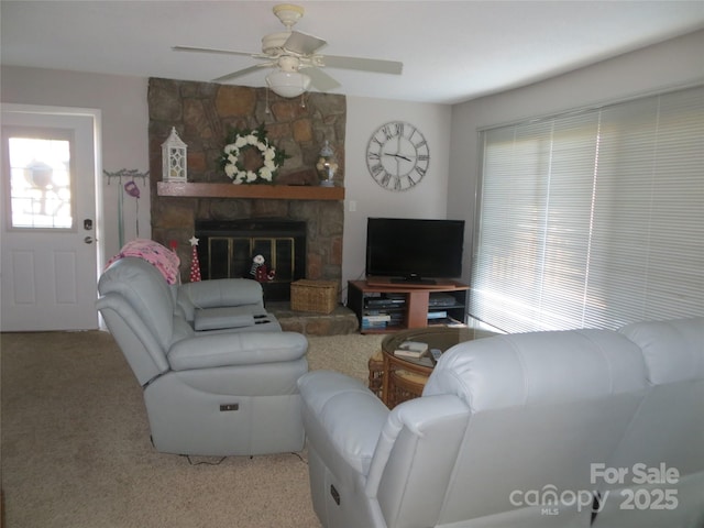 carpeted living room featuring ceiling fan and a fireplace