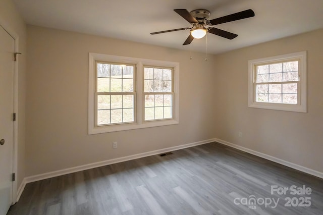 empty room featuring dark wood-type flooring and ceiling fan