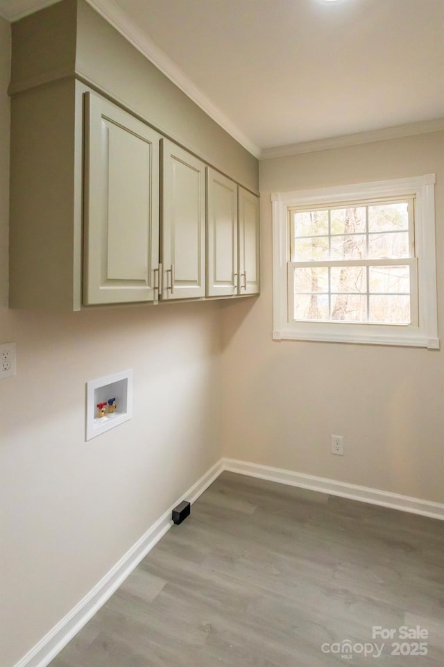 clothes washing area with cabinets, ornamental molding, hookup for a washing machine, and light hardwood / wood-style flooring