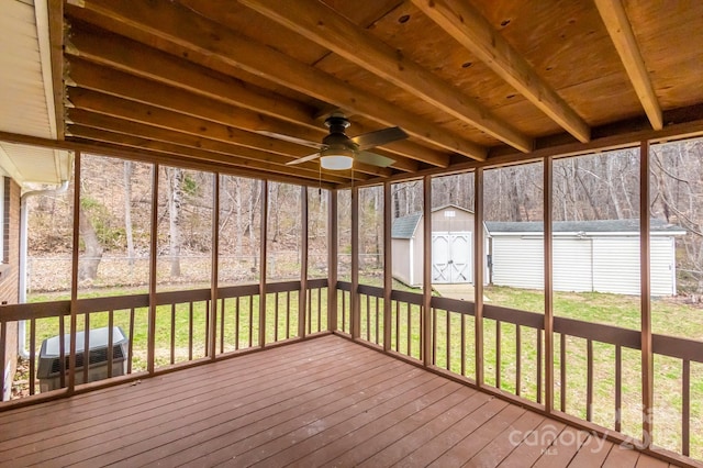 unfurnished sunroom with beamed ceiling and ceiling fan