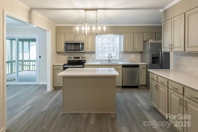 kitchen with appliances with stainless steel finishes, tasteful backsplash, wood finished floors, a sink, and light countertops