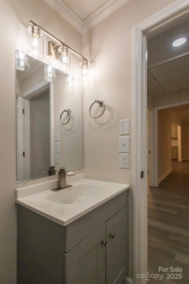 bathroom with vanity, ornamental molding, and wood finished floors