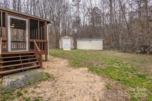 view of yard with fence, an outdoor structure, a sunroom, and a shed