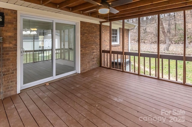 unfurnished sunroom featuring a ceiling fan