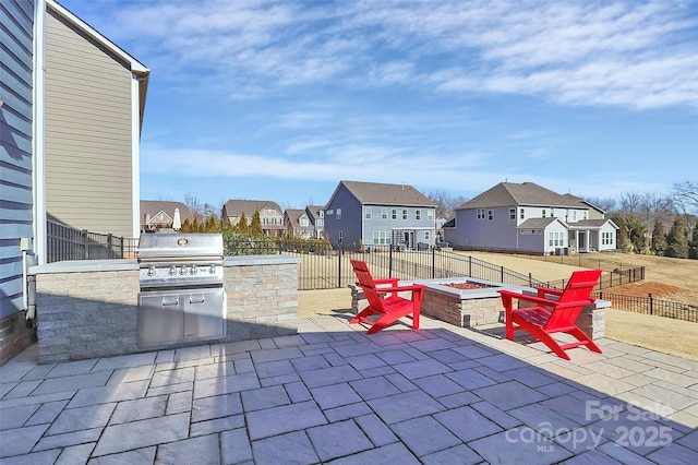 view of patio / terrace with area for grilling, an outdoor fire pit, and exterior kitchen