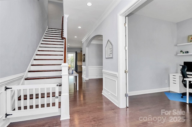 stairs with crown molding and wood-type flooring