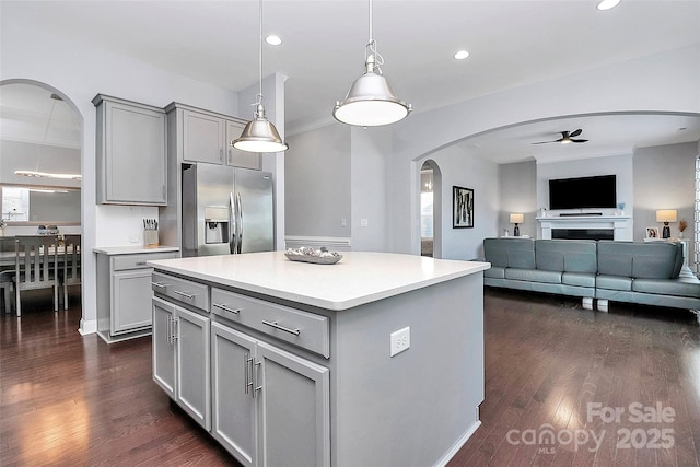 kitchen with a center island, stainless steel fridge, gray cabinets, pendant lighting, and ceiling fan