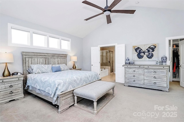 carpeted bedroom with ceiling fan, high vaulted ceiling, connected bathroom, a spacious closet, and a closet