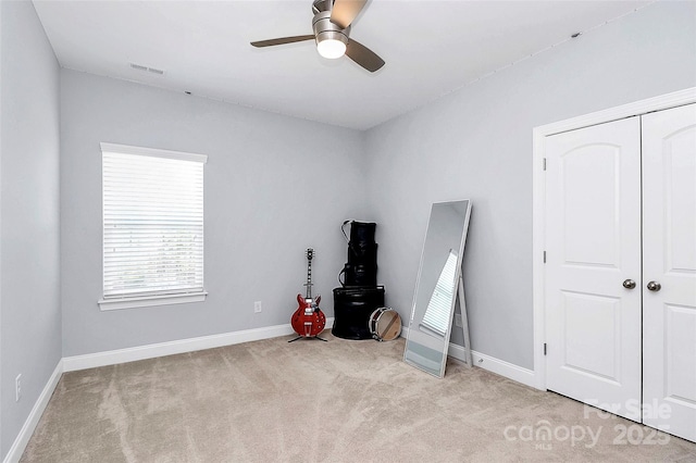 misc room featuring light carpet and ceiling fan