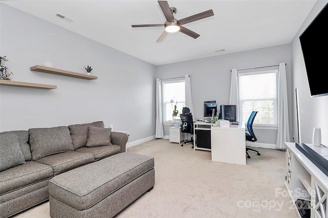 carpeted office space featuring ceiling fan and a healthy amount of sunlight