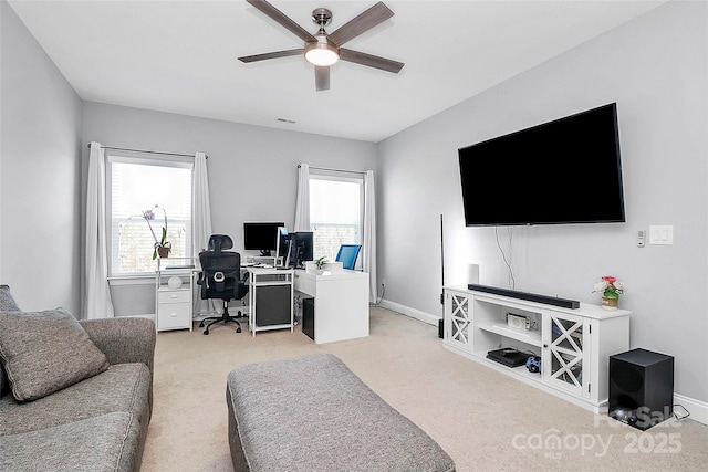 office featuring light carpet, ceiling fan, and a healthy amount of sunlight