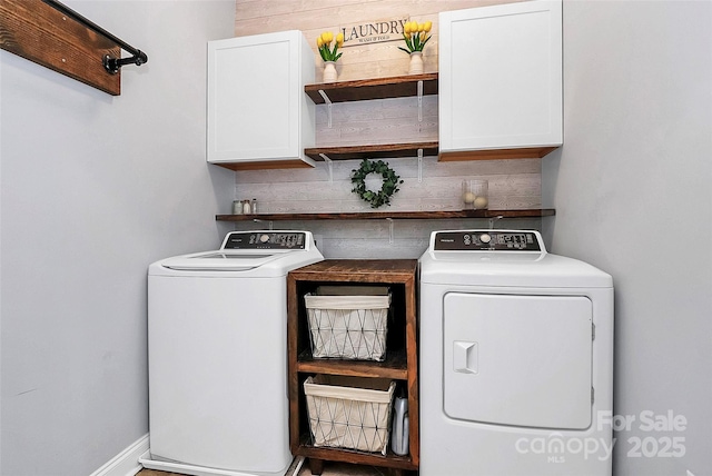 laundry area with separate washer and dryer and cabinets