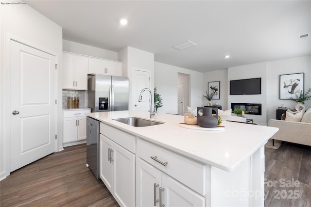 kitchen featuring appliances with stainless steel finishes, sink, a center island with sink, and white cabinets