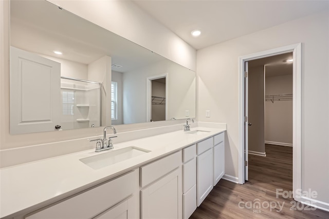 bathroom featuring vanity, a shower, and hardwood / wood-style floors