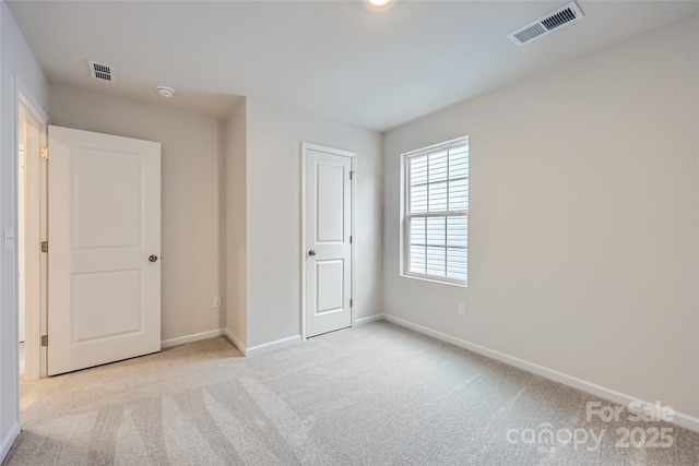 unfurnished bedroom featuring light carpet