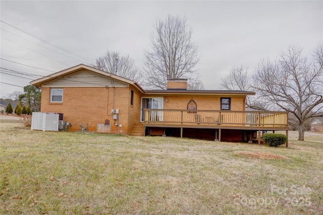 back of property with a yard, a wooden deck, a chimney, and brick siding