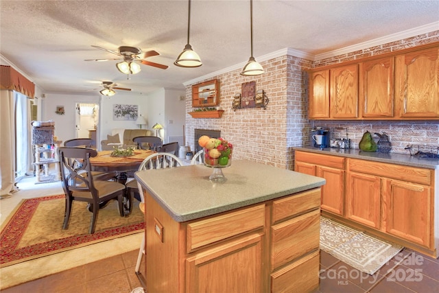 kitchen featuring a brick fireplace, a kitchen island, and a textured ceiling