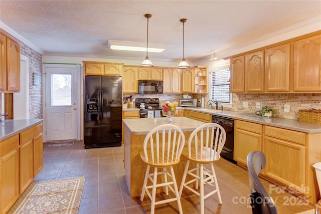 kitchen featuring decorative backsplash, a center island, crown molding, black appliances, and light brown cabinets