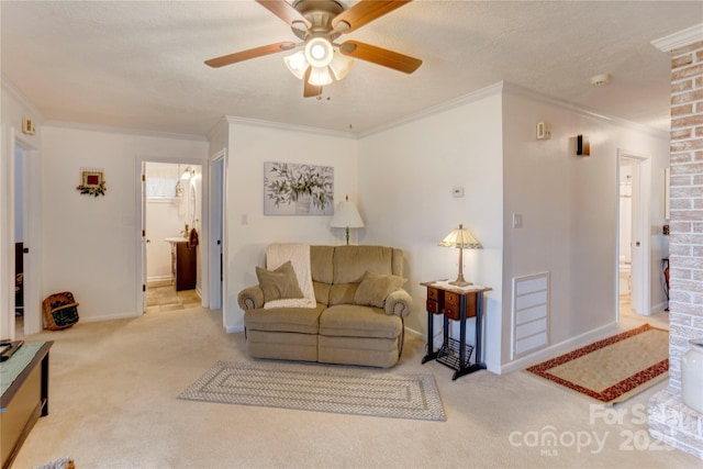 living area with a textured ceiling, carpet floors, visible vents, baseboards, and ornamental molding