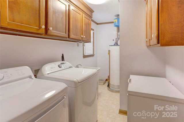 clothes washing area with cabinet space, washing machine and clothes dryer, crown molding, light floors, and gas water heater