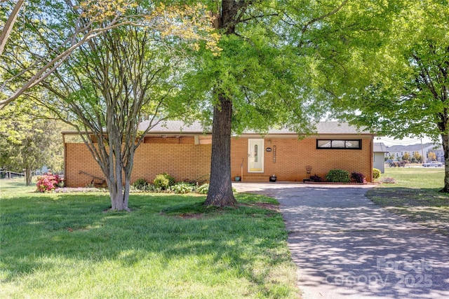 single story home with brick siding, driveway, and a front lawn