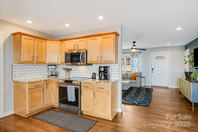 kitchen featuring decorative backsplash, light wood-type flooring, stainless steel appliances, and light stone countertops