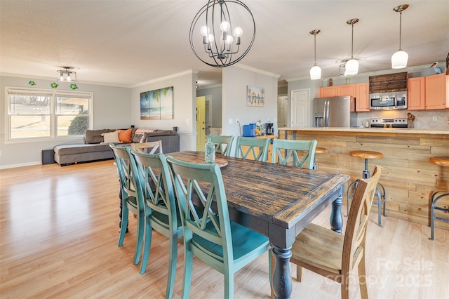 dining room with crown molding and light hardwood / wood-style floors